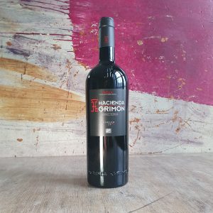 A bottle of Hacienda Grimon Rioja Reserva red wine on a wooden counter